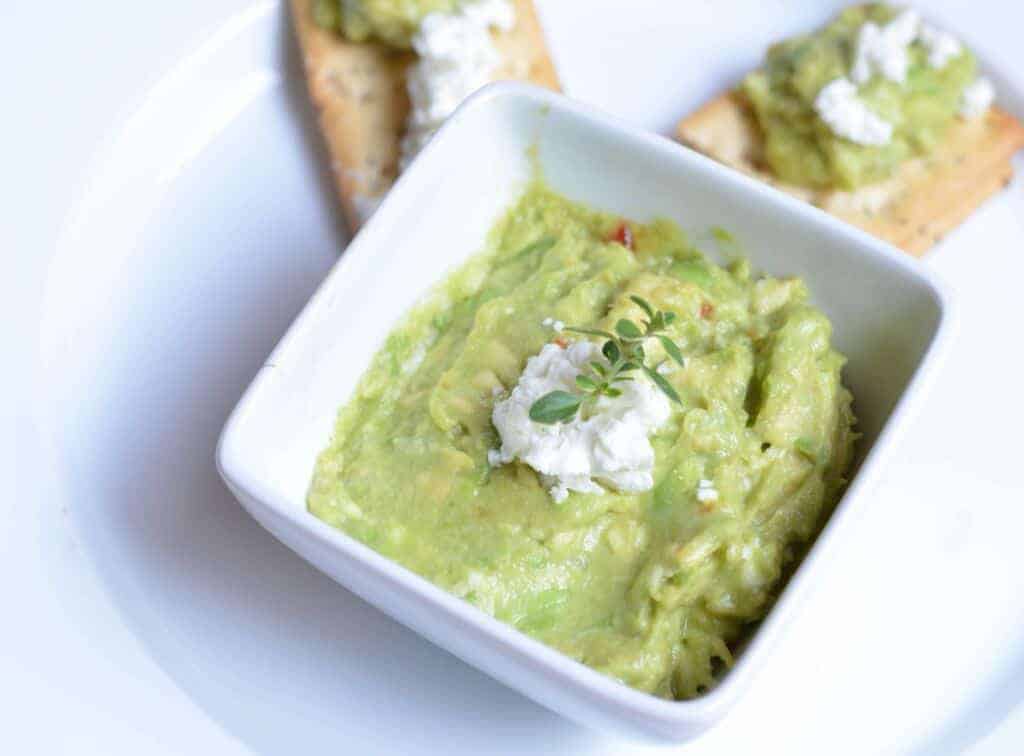 Looking for the perfect easy picnic dip recipe? This homemade guacamole with goat cheese takes about five minutes to make & tastes amazing with veggies!